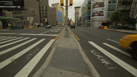 Houston Street - cars driving in traffic two ways - island between streets in NYC