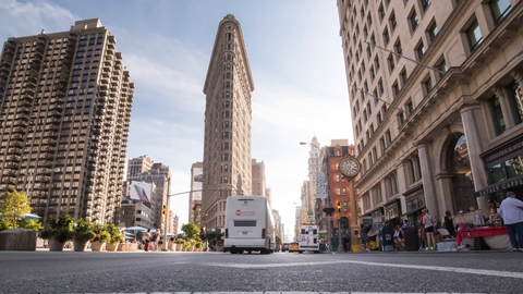 slow tilitng down to road with Flatiron Building and 5th Ave traffic in Manhattan - 4K timelapse in NYC