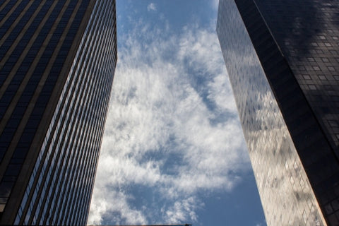 two corporate office buildings - glass windows with reflections of sky and clouds
