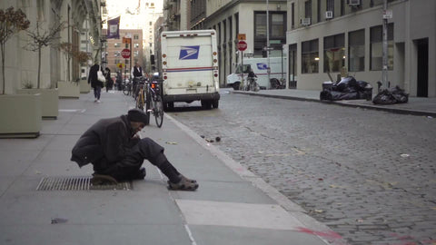 homeless man sitting on street in cold