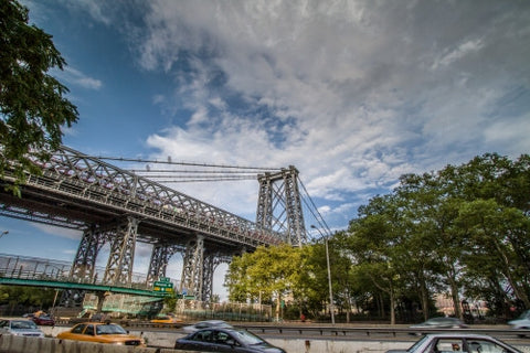 Williamsburg Bridge with Houston Street exit sign in Manhattan with cars driving on FDR Drive highway on bright sunny day
