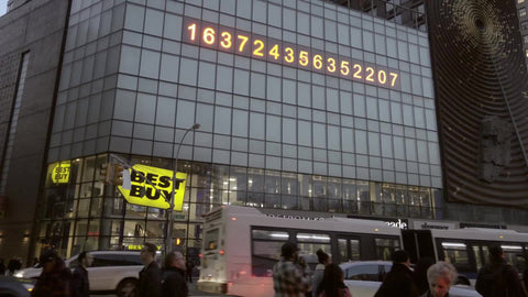 famous ticker numbers in Union Square with cars and people below on busy intersection - Best Buy, Nordstrom Rack, and Duane Reade store sign