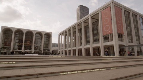 Lincoln Center stairs - panning shot of man standing on steps in 4K Manhattan NYC