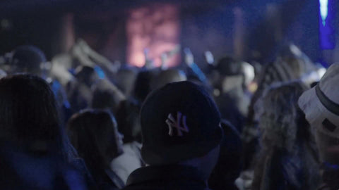 hip hop fans with Yankee hat watching rap show in crowd, fans standing in front of stage