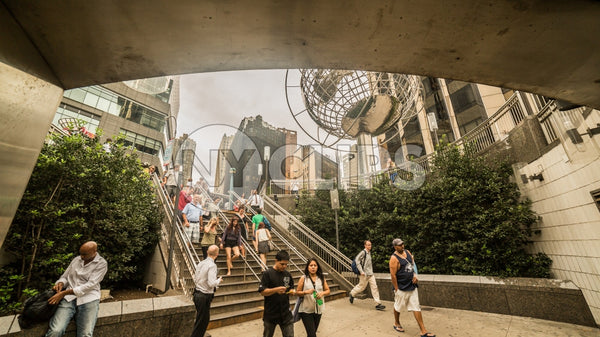 Columbus Circle with famous globe sculpture and student with backpack in Midtown Manhattan on sunny summer day from subway station stairs in NYC