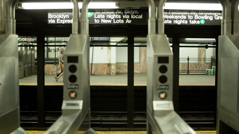 subway train entering station - people exiting turnstiles in NYC