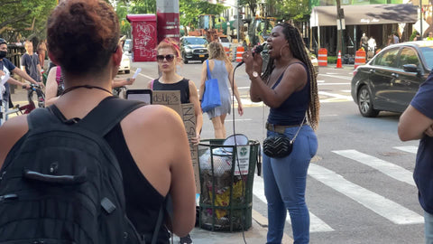 anti-vaxxer activists with microphone and signs on street in New York City NYC
