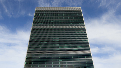 front upward angle of United Nations Building in Manhattan - 4K timelapse with blue sky and clouds