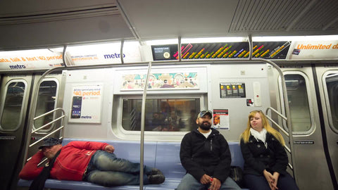 man sleeping on the subway next to couple - homeless guy on moving train in 1080 HD in NYC