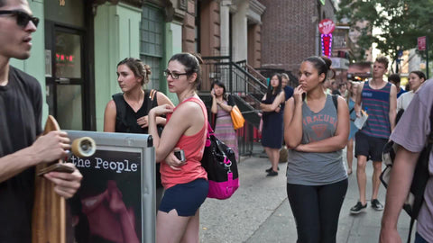 yoga sign in East Village with people entering studio in summer in Manhattan NYC