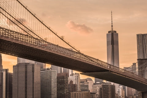 Freedom Tower from across Brooklyn Bridge at sunset with beautiful orange sky in NYC