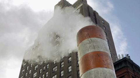 orange and white striped construction site pipe with steam - smoke coming from stack in NYC