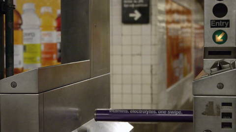 tracking shot of subway turnstile with woman and man entering in train station - 4K slow motion in New York City