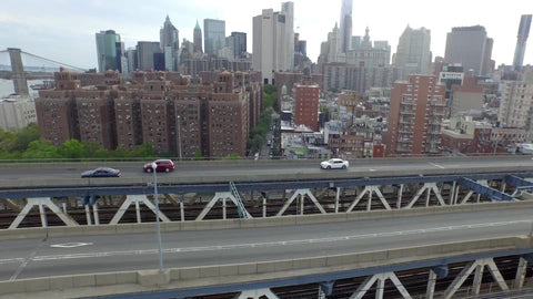 aerial over Manhattan Bridge with cars driving across to Brooklyn on spring day