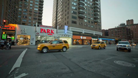 cars and cabs driving on Broadway and Astor Place in daytime Manhattan NYC