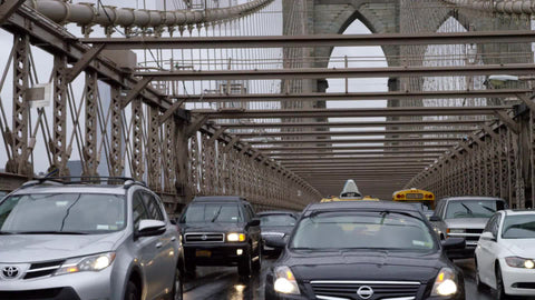 cars driving in traffic on Brooklyn Bridge in rain, windshield wipers on rainy day - raining in slow motion