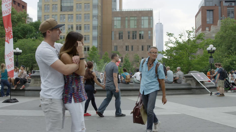 young good looking couple in Washington Square Park with Freedom Tower in background in summer - 4K slow motion in NYC
