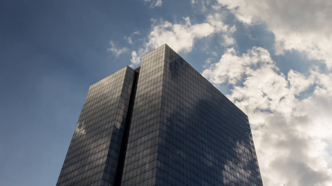 towering glass skyscraper in Manhattan with American flag - 4K timelapse in New York City