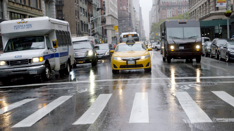 taxi cab driving past crosswalk on wet road in rain with windshield wipers - 4K slow motion in Manhattan NYC