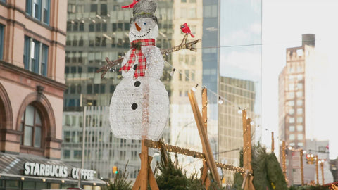 snowman sign over Christmas trees on street in NYC