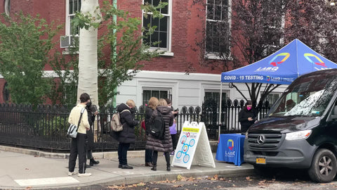 Covid testing van and medical tent setup for free covid-19 test people in line on street New York City