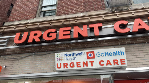 Urgent Care sign overhead panning with snow rain falling blizzard snowing raining winter New York City NYC