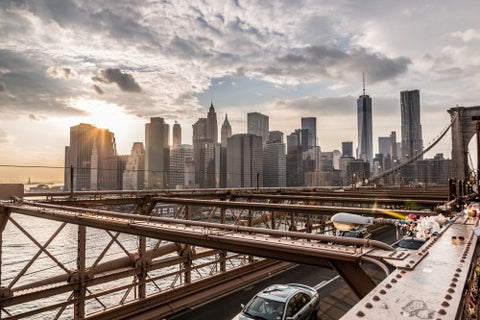 view of Manhattan skyline with skyscrapers and Freedom Tower from Brooklyn Bridge at sunset in NYC
