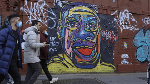 group of guys walk by George Floyd mural on street in Lower East Side Manhattan New York City NYC