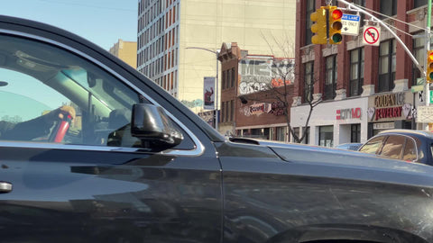 NYPD police officer sticker on vehicle turning corner food delivery man on bicycle of 125th street and Lenox Ave in Harlem New York City NYC