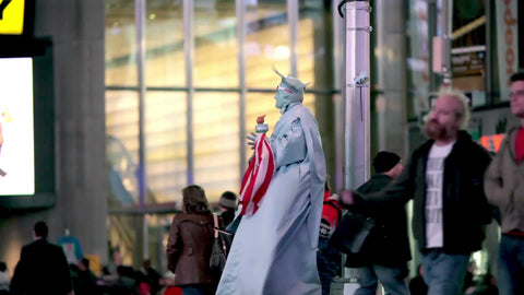 Statue of Liberty performer in costume in Times Square on windy fall night in NYC