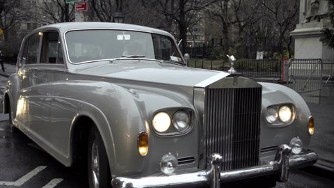 Rolls-Royce classic luxury car panning to Lower Fifth Avenue traffic cars and taxi cabs at crosswalk in Manhattan 1080