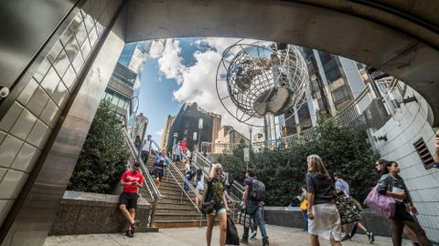 Columbus Circle with famous globe sculpture and people in Midtown Manhattan on sunny summer day from subway station stairs in NYC