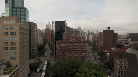 flying over American flag on Cooper Union building in Manhattan with buildings New York City NYC