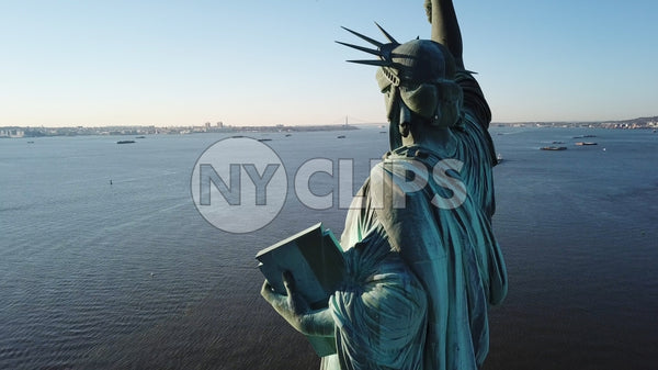 Statue of Liberty facing open harbor in New York City - aerial in water