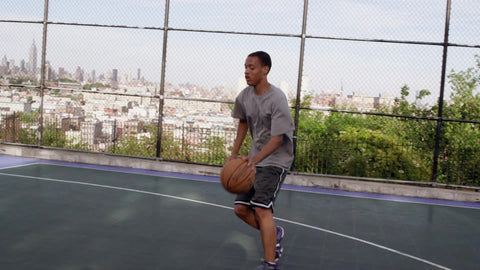 young athlete driving to basket and scoring layup - practicing basketball on outdoor court in summer