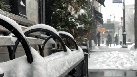 snowy bench in winter blizzard snowing on cold day in New York City NYC