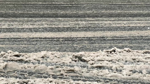 car tires driving through snow slush and sleet - closeup of wheels on street in bad weather in winter 1080