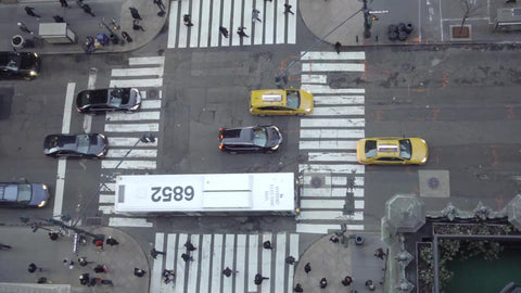 aerial view of cars driving in traffic and intersection crosswalk below in Midtown Manhattan in 1080 HD and 4K in NYC