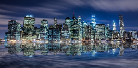 Manhattan skyline glowing with Freedom Tower under construction late at night across East River in HDR