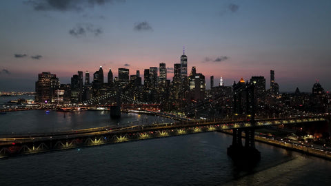 aerial over East River water Brooklyn Bridge two bridges Manhattan skyline sunset in New York City NYC