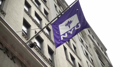 NYU flag on rainy day - raining at front doors of administrative university building - man entering