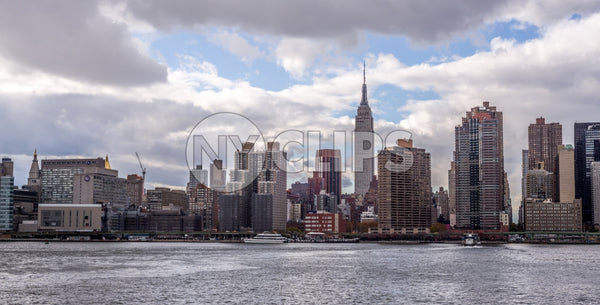 Empire State Building in daytime skyline from across East River water in Manhattan NYC