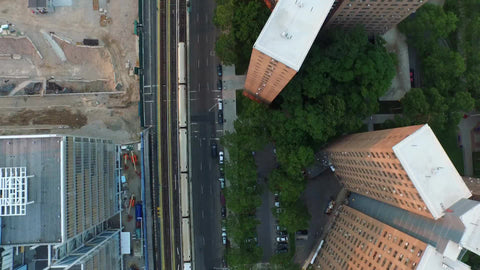 1 train passing through Harlem on elevated track - aerial of subway in Uptown Manhattan