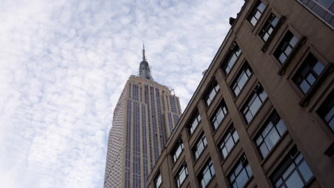 Empire State Building view from driving vehicle - buildings and blue sky