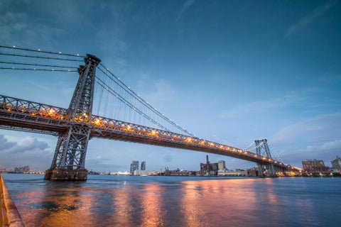 Williamsburg Bridge in Brooklyn late at night - early evening over East River with reflections in water
