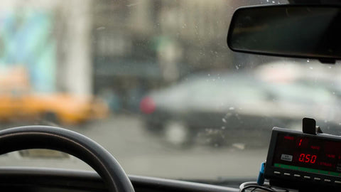 taxi driver stopped at busy intersection waiting for light to change