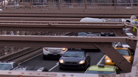 Brooklyn Bridge zooming out from close-up of cars in traffic - timelapse with Manhattan in background in 4K and 1080 HD NYC