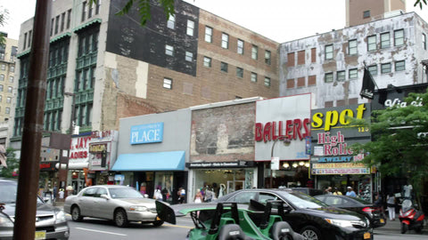 panning across 125th street in Harlem to famous Apollo Theater marquee and entrance sign in NYC