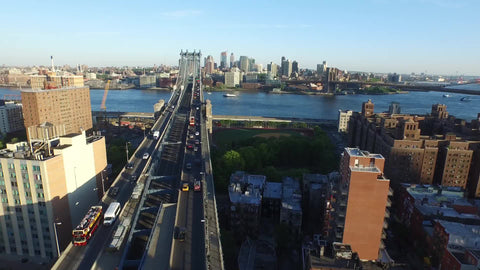 aerial moving toward Manhattan Bridge and East River - cars driving across to Brooklyn