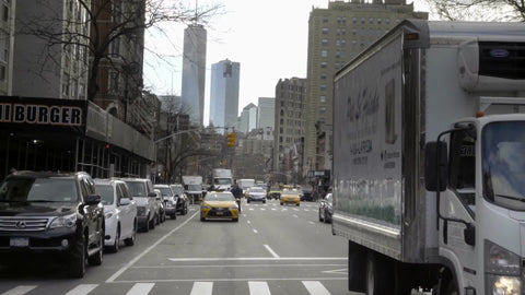 6th Ave traffic in Manhattan, Freedom Tower skyscraper in view with cars and taxicab driving in NYC